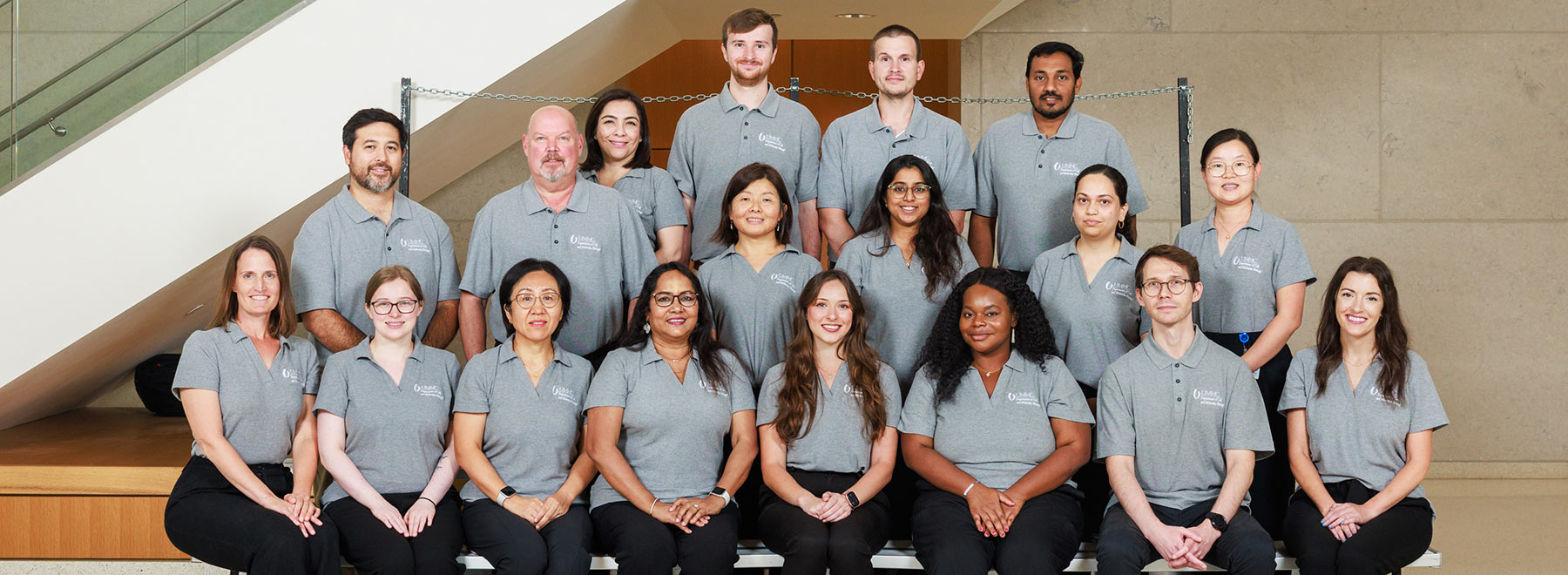 Group portrait of members of the Department of Cell and Molecular Biology inside the School of Medicine lobby. There is a stairase behind them.